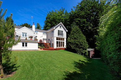 На фото: двухэтажный, деревянный, белый дом в классическом стиле с