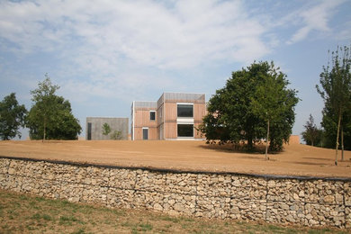 Foto della facciata di una casa grande marrone contemporanea a un piano con rivestimento in legno e tetto piano