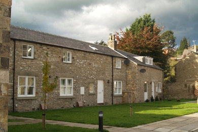 Expansive traditional two floor terraced house in Other with stone cladding, a pitched roof and a tiled roof.