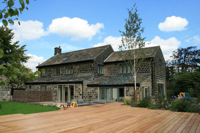 Modelo de fachada de casa grande de dos plantas con revestimiento de piedra, tejado a dos aguas y tejado de teja de barro