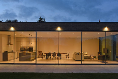 Diseño de fachada de casa actual de tamaño medio de una planta con revestimiento de ladrillo y tejado plano