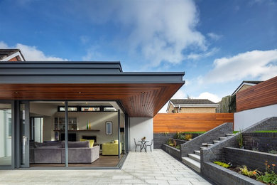 Réalisation d'une façade de maison blanche design en stuc de taille moyenne et de plain-pied avec un toit plat et un toit en métal.