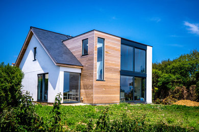 Kleine, Zweistöckige Nordische Holzfassade Haus mit weißer Fassadenfarbe und Flachdach in Kanalinseln