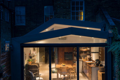 Contemporary terraced house in London with metal cladding and a metal roof.