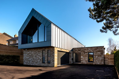 Ejemplo de fachada de casa azul moderna de tamaño medio de dos plantas con revestimiento de metal, tejado a dos aguas y tejado de metal