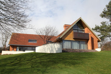Photo of a large contemporary two floor brick house exterior in Hampshire.