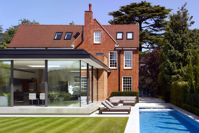 Großes, Dreistöckiges Modernes Einfamilienhaus mit Mix-Fassade, roter Fassadenfarbe und Halbwalmdach in London