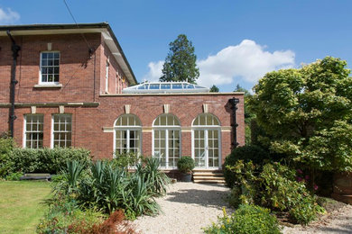 Foto de fachada de casa roja y gris clásica de tamaño medio de una planta con revestimiento de ladrillo y tejado plano