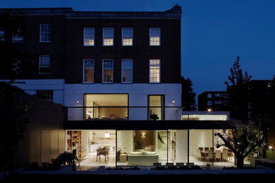 Inspiration for a large and red contemporary glass house exterior in London with three floors and a flat roof.