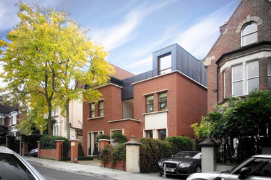 Large and red contemporary brick house exterior in London with three floors and a hip roof.