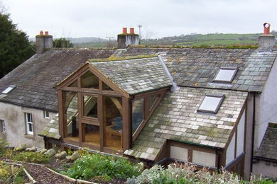 Imagen de fachada de casa campestre de dos plantas con tejado a dos aguas
