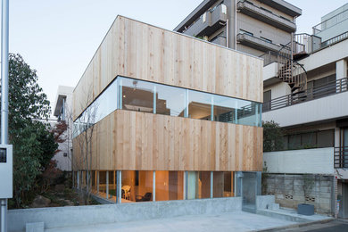 Réalisation d'une façade de maison design en bois à un étage avec un toit plat.