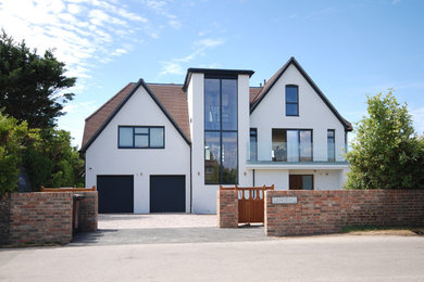 Design ideas for a white and large contemporary render detached house in Surrey with three floors, a pitched roof and a tiled roof.