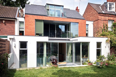 This is an example of a medium sized and multi-coloured contemporary brick terraced house in London with three floors, a pitched roof and a mixed material roof.