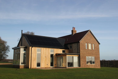 Modelo de fachada de casa multicolor contemporánea de tamaño medio de dos plantas con revestimiento de ladrillo, tejado a dos aguas y tejado de varios materiales