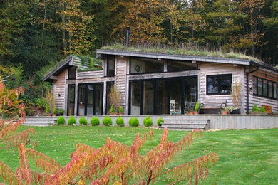Inspiration for a rustic detached house in Hampshire with wood cladding, a pitched roof and a green roof.