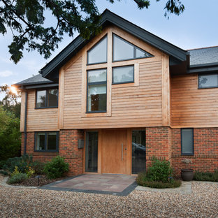Brown rustic two floor detached house in Berkshire with wood cladding and a pitched roof.