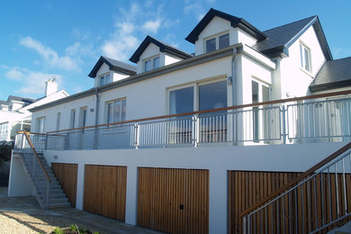 Inspiration for a large and white modern two floor render detached house in Dublin with a pitched roof and a tiled roof.