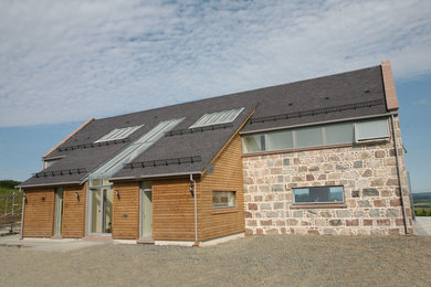 This is an example of a contemporary two floor house exterior in Other with mixed cladding and a pitched roof.