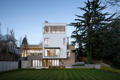 Photo of a large contemporary house exterior in Other with three floors, mixed cladding and a flat roof.