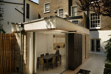This is an example of a multi-coloured contemporary brick and rear house exterior in London with three floors.