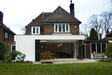 This is an example of a white bohemian house exterior in Other with mixed cladding.
