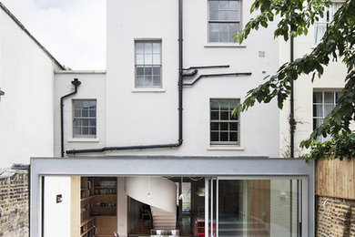 Imagen de fachada de casa bifamiliar gris moderna grande de tres plantas con revestimiento de estuco, tejado plano y tejado de varios materiales
