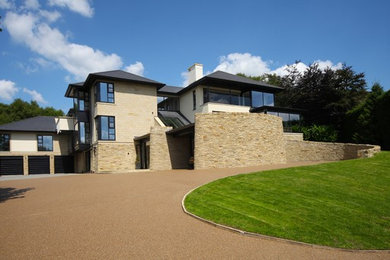 Inspiration for a large and beige contemporary house exterior in Manchester with three floors, stone cladding and a pitched roof.