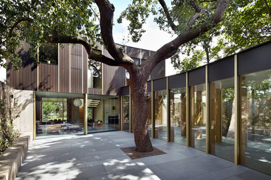 Cette image montre une grande façade de maison design en bois de plain-pied avec un toit plat.