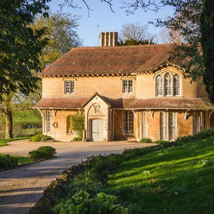 Photo of a brown shabby-chic style detached house in Other with a half-hip roof.