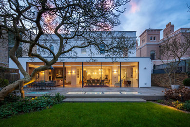 Photo of a white contemporary two floor house exterior in London with a flat roof.
