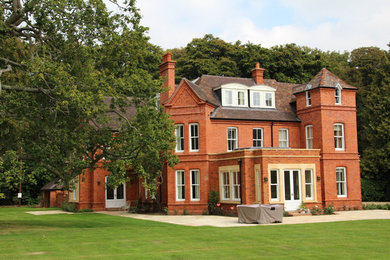 Inspiration for a large and red classic brick house exterior in Oxfordshire with three floors.