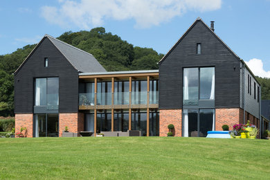 Inspiration for a large and black country two floor detached house in Other with wood cladding and a pitched roof.