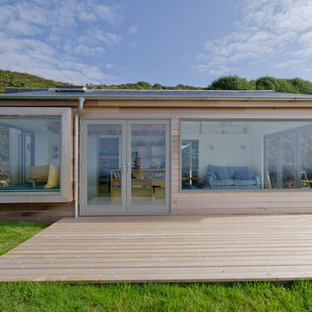 Photo of a small and beige contemporary one floor detached house in Cornwall with wood cladding and a flat roof.