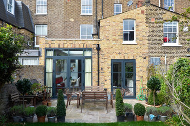 Inspiration for a medium sized and beige bohemian brick house exterior in London with three floors.