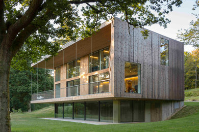 Modelo de fachada marrón contemporánea grande de tres plantas con revestimiento de madera y tejado plano