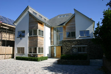 Diseño de fachada blanca contemporánea extra grande de tres plantas con revestimiento de estuco y tejado a dos aguas