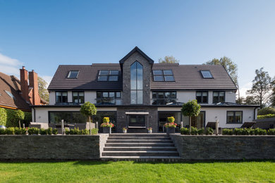 Ejemplo de fachada de casa gris minimalista grande con revestimientos combinados, tejado a dos aguas y tejado de teja de barro