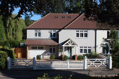 Diseño de fachada gris de estilo de casa de campo de tamaño medio de dos plantas con revestimiento de estuco y tejado a cuatro aguas