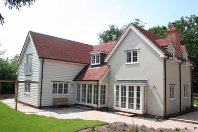 This is an example of a large and beige traditional two floor detached house in Other with mixed cladding, a pitched roof and a tiled roof.