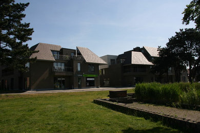 Imagen de fachada marrón actual grande de tres plantas con revestimiento de ladrillo y tejado a la holandesa