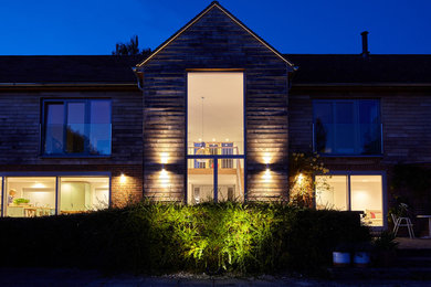 Photo of a medium sized farmhouse house exterior in Wiltshire with wood cladding.