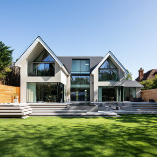 Photo of a white contemporary two floor detached house in Surrey with a pitched roof and a grey roof.