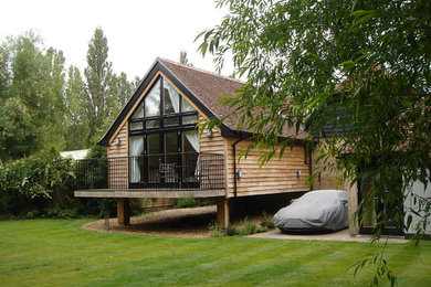 Photo of a brown contemporary two floor house exterior in London with wood cladding and a pitched roof.