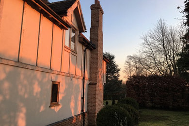 Large and gey farmhouse two floor house exterior in Essex with a pitched roof.