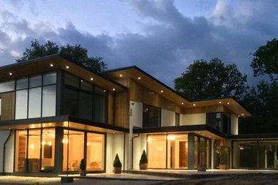 ハンプシャーにある高級なモダンスタイルのおしゃれな二階建ての家 (ガラスサイディング) の写真
