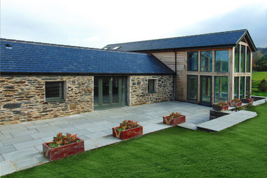 Ejemplo de fachada de casa blanca campestre extra grande de dos plantas con revestimiento de madera, tejado a dos aguas y tejado de teja de barro