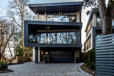 This is an example of a large and multi-coloured contemporary detached house in Other with three floors, mixed cladding and a flat roof.