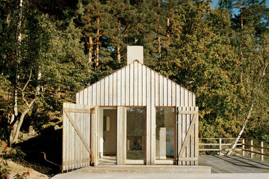 Diseño de fachada beige nórdica pequeña de una planta con revestimiento de madera y tejado a dos aguas