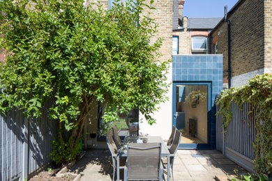 Inspiration for a blue contemporary bungalow terraced house in London with a flat roof.